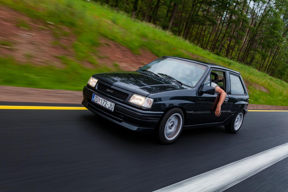 Klasična 'Opel fahrer' drža: odprta šipa in roka skozi okno.