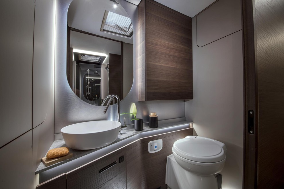Velika kopalnica z ločenim umivalnikom in tuš kabino s tuš stolpom Alde, stenskim ogrevanjem, držalom za brisače in obešalniki.