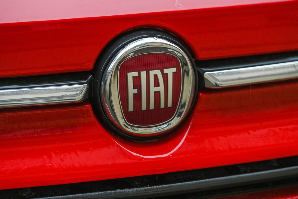Fiatov logotip na rdečem avtomobilu od blizu.